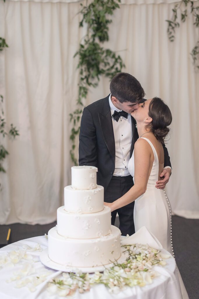 Couple Kissing At The Cake Cutting Ceremony

