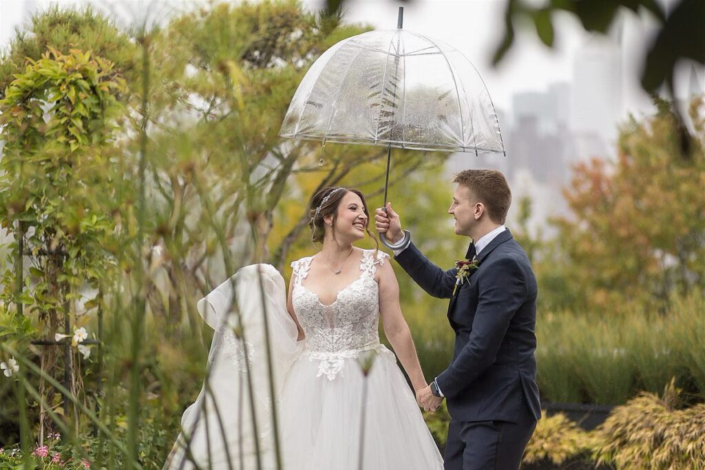 Groom Holding Umbrella On Bride's Head

